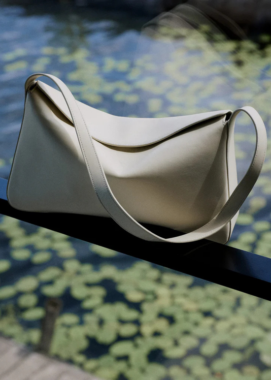 white leather handbag above a lily pond
